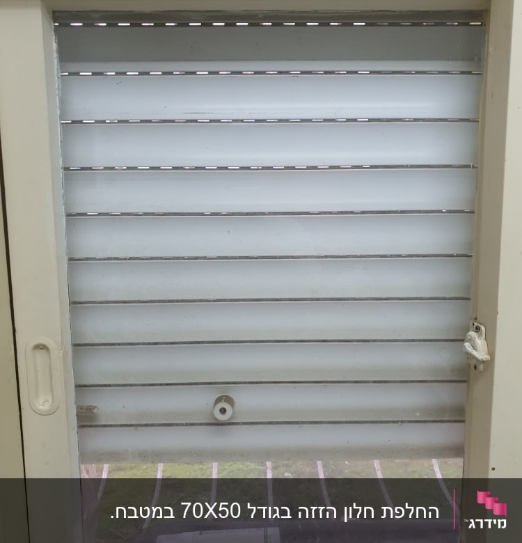 חלון זכוכית עם תריסים סגורים חלקית